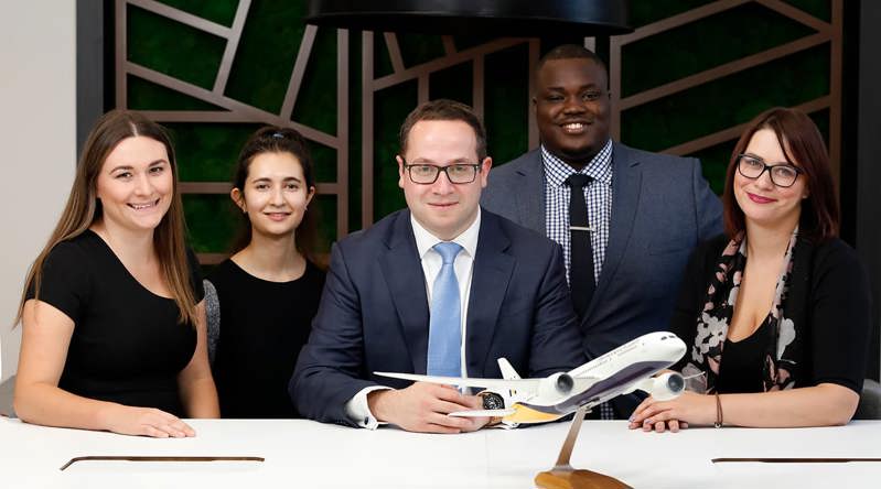 Some of our specialist aviation lawyers posing in our London office with a model plane